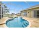 Screened-in Kidney-shaped pool with spa and travertine deck at 1204 Blackrush Dr, Tarpon Springs, FL 34689