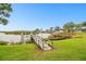 Picturesque waterfront view showcasing a private wooden dock and lush landscaping at 1204 Blackrush Dr, Tarpon Springs, FL 34689