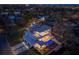 Magnificent aerial view of a modern home with a pool, large balcony, and well-lit exterior at night at 1401 Brightwaters Ne Blvd, St Petersburg, FL 33704