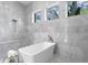 Spa-like bathroom with marble tile, freestanding tub, rain shower, and large windows at 1401 Brightwaters Ne Blvd, St Petersburg, FL 33704