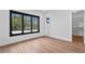 Bright bedroom featuring hardwood floors, modern windows, and a walk-in closet for ample storage at 1401 Brightwaters Ne Blvd, St Petersburg, FL 33704