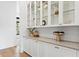 A butler pantry with custom cabinets, glass shelving, and elegant décor at 1401 Brightwaters Ne Blvd, St Petersburg, FL 33704