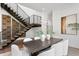 Elegant dining room featuring a modern chandelier, wood table with white chairs, and a unique staircase at 1401 Brightwaters Ne Blvd, St Petersburg, FL 33704