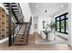 Dining room with modern light fixture, black frame windows, and wood staircase with wine cellar at 1401 Brightwaters Ne Blvd, St Petersburg, FL 33704