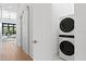 Hallway laundry area boasts modern stackable washer and dryer units and a convenient sliding door at 1401 Brightwaters Ne Blvd, St Petersburg, FL 33704