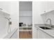 Bright, streamlined laundry room with white cabinetry, subway tile, and a convenient washing station for pets at 1401 Brightwaters Ne Blvd, St Petersburg, FL 33704