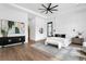 Airy main bedroom with modern decor, large window, dark cabinet, and a seating bench at the end of the bed at 1401 Brightwaters Ne Blvd, St Petersburg, FL 33704