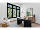 Modern home office with large black windows, sleek dark wood desk, and stylish decor elements at 1401 Brightwaters Ne Blvd, St Petersburg, FL 33704
