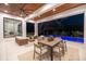 A covered patio includes an outdoor dining area and luxurious seating with views of the pool and landscape at 1401 Brightwaters Ne Blvd, St Petersburg, FL 33704