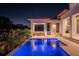 Inviting modern pool area with vibrant blue lighting, a covered patio, and lush tropical landscaping at 1401 Brightwaters Ne Blvd, St Petersburg, FL 33704