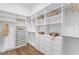 Bright walk-in closet with custom white shelving and drawers, maximizing organization and storage at 1401 Brightwaters Ne Blvd, St Petersburg, FL 33704