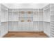 Spacious walk-in closet features custom shelving, drawers, and wooden floors for ample storage at 1401 Brightwaters Ne Blvd, St Petersburg, FL 33704