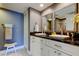 Bathroom featuring double sinks with black countertops and white cabinets and access to a shower at 1460 Gulf Blvd # 506, Clearwater Beach, FL 33767