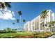 The condo building is set on a manicured lawn with palm trees, tropical plants and lush green grass at 1460 Gulf Blvd # 506, Clearwater Beach, FL 33767