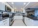 Bright kitchen boasts white cabinets, stainless appliances, and tiled backsplash at 1460 Gulf Blvd # 506, Clearwater Beach, FL 33767