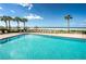 Inviting outdoor pool surrounded by lounge chairs, palm trees, and a picturesque beachfront setting at 1460 Gulf Blvd # 506, Clearwater Beach, FL 33767