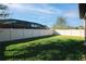Grassy backyard with privacy fence, backing up to a screened in pool and lanai at 1593 Secluded Garden Ln, Lutz, FL 33558