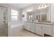 Bathroom with tiled shower, soaking tub, double vanity with granite countertop, and linen storage at 1593 Secluded Garden Ln, Lutz, FL 33558