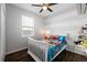 Cozy bedroom with a ceiling fan, window and a theme bed and toy storage at 1593 Secluded Garden Ln, Lutz, FL 33558
