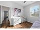 Cozy bedroom with a sunny window, wood-look tile flooring, and white dresser at 1593 Secluded Garden Ln, Lutz, FL 33558