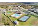 Aerial view of a community pool, tennis and basketball courts next to a serene lake at 1593 Secluded Garden Ln, Lutz, FL 33558