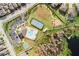 Overhead view of community amenities including a pool, tennis court, playground, parking, and lake access at 1593 Secluded Garden Ln, Lutz, FL 33558