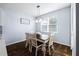 Bright dining room with a modern light fixture, white chairs and dark wood table at 1593 Secluded Garden Ln, Lutz, FL 33558