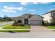 Charming single-story home with a brick-paved driveway and well-manicured lawn at 1593 Secluded Garden Ln, Lutz, FL 33558