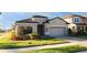 Charming single-Gathering home with a well-manicured lawn, a two-car garage, and a stylish gray exterior at 1593 Secluded Garden Ln, Lutz, FL 33558