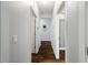 Hallway featuring neutral paint, wood-look tile flooring, and access to multiple rooms at 1593 Secluded Garden Ln, Lutz, FL 33558