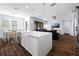 Modern open concept kitchen with stainless appliances, island with seating and connection to a dining area at 1593 Secluded Garden Ln, Lutz, FL 33558