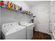 Laundry room featuring modern washer and dryer with built in shelving at 1593 Secluded Garden Ln, Lutz, FL 33558