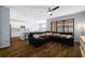 Open-concept living room with wood floors, ceiling fan, a kitchen, a dining area, and a large sectional sofa at 1593 Secluded Garden Ln, Lutz, FL 33558