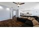 Open-concept living room features modern ceiling fan, wood-look flooring, and flows into the kitchen at 1593 Secluded Garden Ln, Lutz, FL 33558