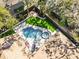 Aerial view of a private backyard with a pool, spa, lush lawn, and patio area at 1708 Country Trails Dr, Safety Harbor, FL 34695