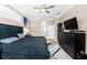 Well-lit bedroom featuring hardwood flooring, a ceiling fan, and large TV mounted on the wall at 1708 Country Trails Dr, Safety Harbor, FL 34695