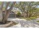 Attractive home showcasing mature trees in the front yard, a well-manicured lawn, and a large driveway at 1708 Country Trails Dr, Safety Harbor, FL 34695