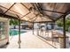 Gazebo next to the pool features stylish seating and hanging plants, perfect for entertaining at 1772 Indian Rocks S Rd, Largo, FL 33774
