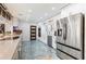 Bright kitchen with stainless steel appliances, white cabinets, and blue marble-style flooring at 1772 Indian Rocks S Rd, Largo, FL 33774
