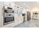 Modern kitchen with stainless appliances, white cabinets, and marble-style flooring at 1772 Indian Rocks S Rd, Largo, FL 33774