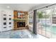 Cozy living room featuring a stone fireplace, blue floors, and a view of the pool at 1772 Indian Rocks S Rd, Largo, FL 33774