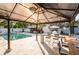 Outdoor entertaining area with pool, bar, and seating under a large pavilion at 1772 Indian Rocks S Rd, Largo, FL 33774