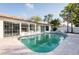Inviting backyard pool area with lush landscaping, travertine decking, and outdoor entertaining space at 1772 Indian Rocks S Rd, Largo, FL 33774