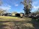 Expansive backyard featuring lush greenery, a storage shed, and beautiful trees, perfect for outdoor enjoyment at 18401 Hamilton Rd, Dade City, FL 33523