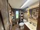 Rustic bathroom featuring unique wood paneling, a functional vanity, and a cozy atmosphere for a relaxing experience at 18401 Hamilton Rd, Dade City, FL 33523