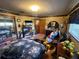 Relax in this bedroom featuring a dark floral comforter, treadmill, and multiple dressers for clothing storage at 18401 Hamilton Rd, Dade City, FL 33523