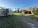 Exterior with a garage and a shed, complimented by a well-maintained lawn and landscape at 18401 Hamilton Rd, Dade City, FL 33523