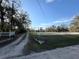 Long gravel drive leading to home surrounded by white picket fence and a spacious, grassy front yard at 18401 Hamilton Rd, Dade City, FL 33523