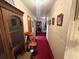 Hallway with red carpet and framed photos on the patterned walls at 18401 Hamilton Rd, Dade City, FL 33523