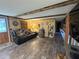 Comfortable living room features wood paneling, a cozy recliner, and decorative elements that enhance the rustic charm at 18401 Hamilton Rd, Dade City, FL 33523